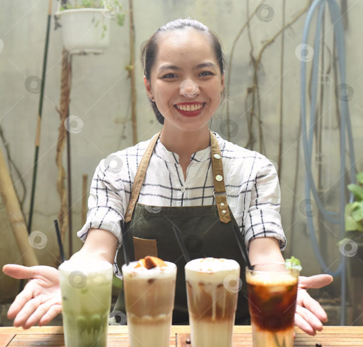 Скачать Азиатка-официантка готовила напитки для подачи в кофейне фотосток Ozero
