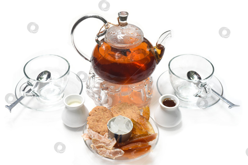 Скачать Чай "Эрл Грей" в стеклянном чайнике с чашечками и засахаренными фруктами на белом фоне фотосток Ozero