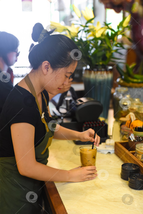 Скачать Вьетнамская официантка готовит кофе в кофейне фотосток Ozero