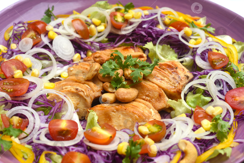 Скачать Курица, обжаренная на сковороде с зеленью и овощами крупным планом на фиолетовой тарелке фотосток Ozero