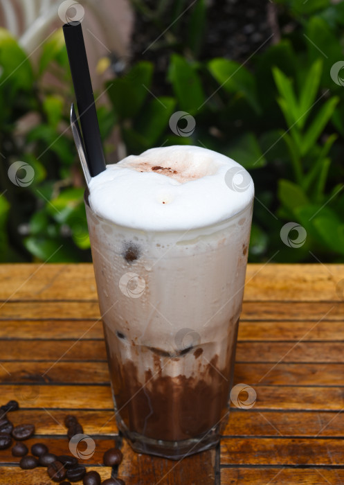 Скачать Кофейный коктейль с мороженым и шоколадом на деревянном столе с кофейными зернами фотосток Ozero