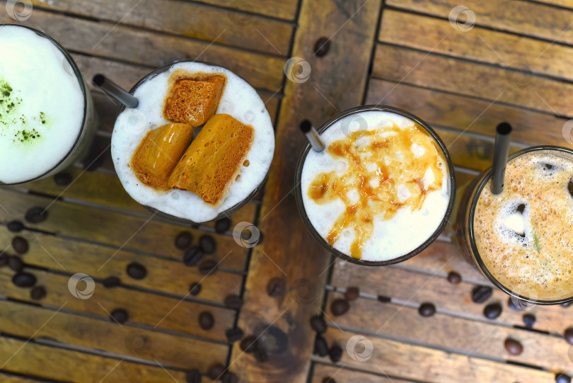 Скачать Кофейные напитки с кофейными зернами на деревянном столе в кофейне фотосток Ozero