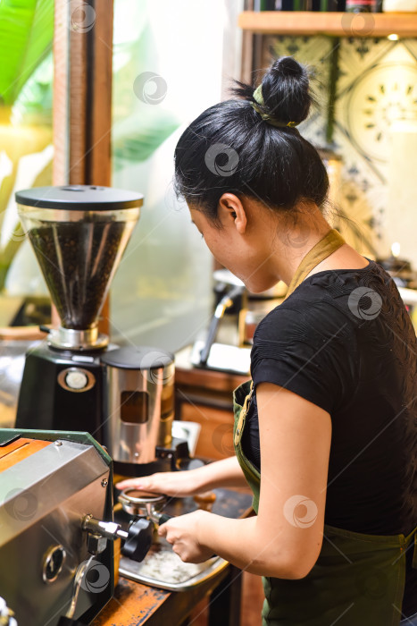 Скачать Вьетнамская официантка готовит кофе с помощью портафильтра кофемашины фотосток Ozero