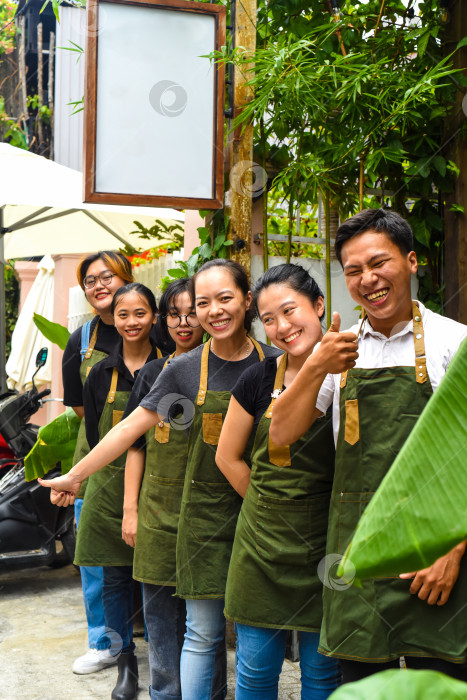 Скачать Команда вьетнамской кофейни улыбается и стоит вместе на фоне кафе фотосток Ozero