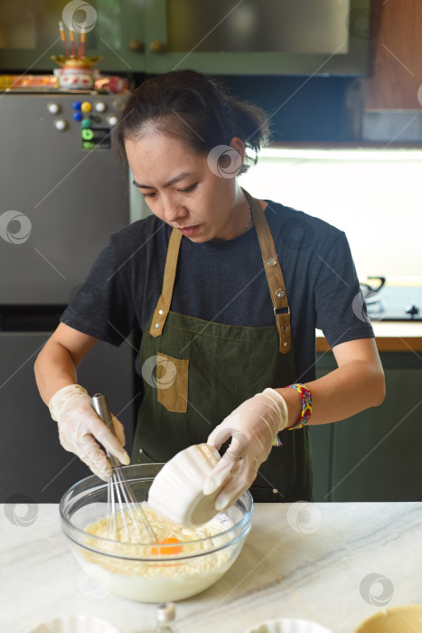 Скачать Молодая вьетнамка замешивает тесто для торта фотосток Ozero