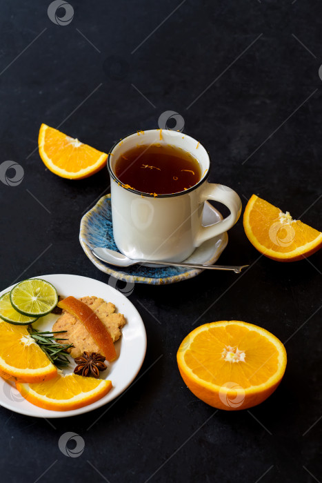 Скачать Апельсиново-коричный чай с засахаренными фруктами и печеньем на черной глазури фотосток Ozero