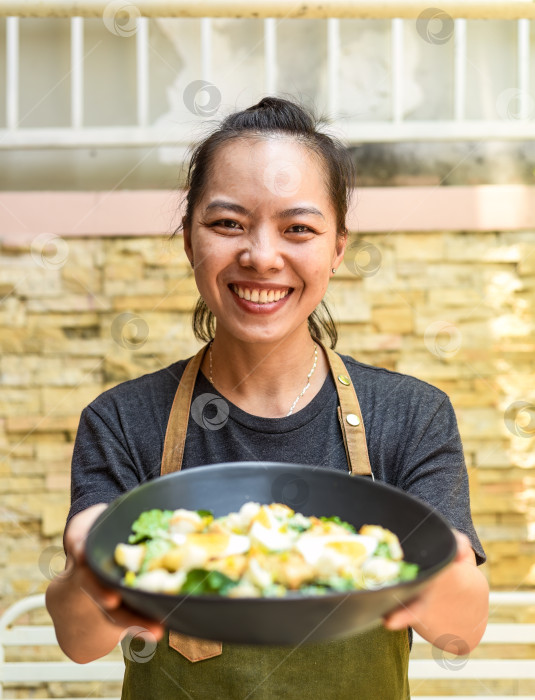 Скачать Вьетнамская счастливая официантка готовит салат "Цезарь" фотосток Ozero