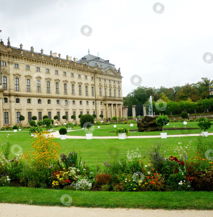 Скачать Вид на Дворец Епископа, фонтан, цветочные композиции в саду дворца, Германия фотосток Ozero