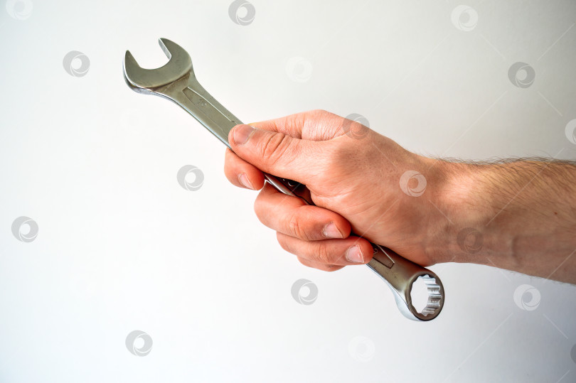 Скачать Мужская рука, держащая гаечный ключ, выделена на белом фоне фотосток Ozero