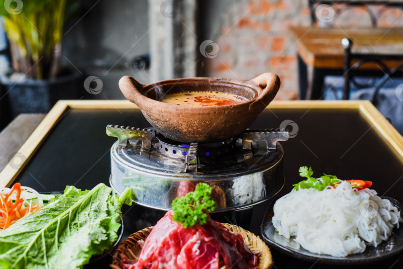 Скачать Корейская острая запеканка с говядиной и лапшой на кирпичном фоне фотосток Ozero