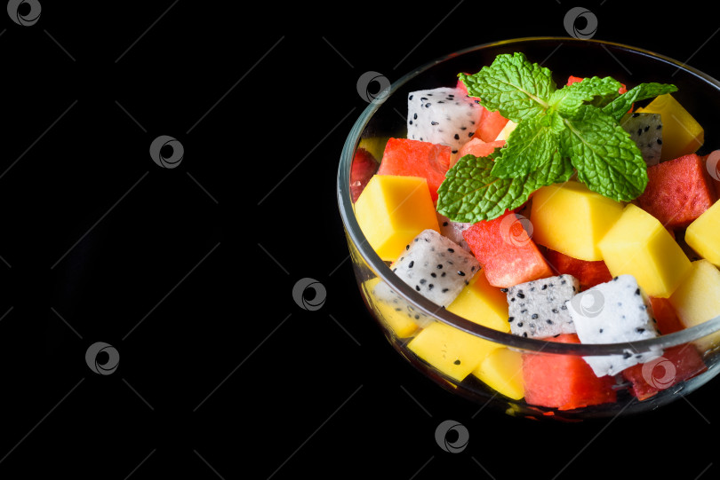 Скачать Фруктовый салат из восточноазиатских фруктов, выделенных на черном фоне, вид сбоку фотосток Ozero