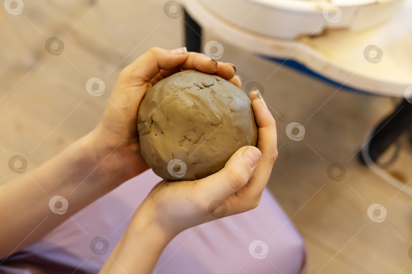 Скачать Ребенок мнет руками большой кусок глины для лепки фотосток Ozero