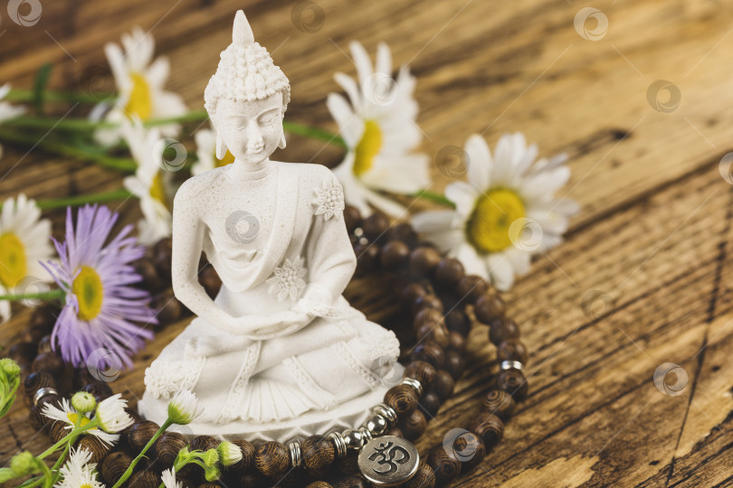 Скачать Открытка на День Весака со статуей Будды, молитвенными четками и полевыми цветами фотосток Ozero