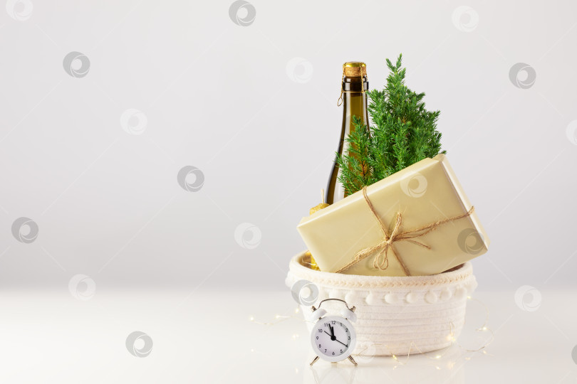 Скачать Посаженная дома рождественская елка, бутылка шампанского, свеча, подарок и часы фотосток Ozero
