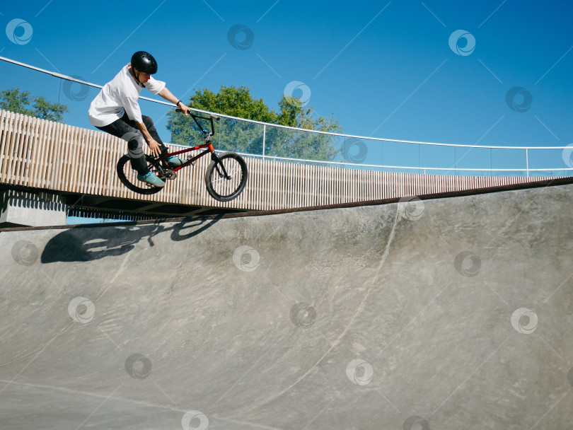 Скачать Гонщик BMX выполняет воздушный трюк на квотерпайпе фотосток Ozero