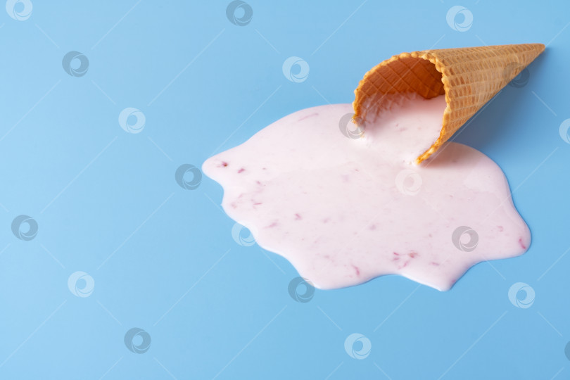 Скачать Розовое мороженое тает и вытекает из вафельного рожка. фотосток Ozero