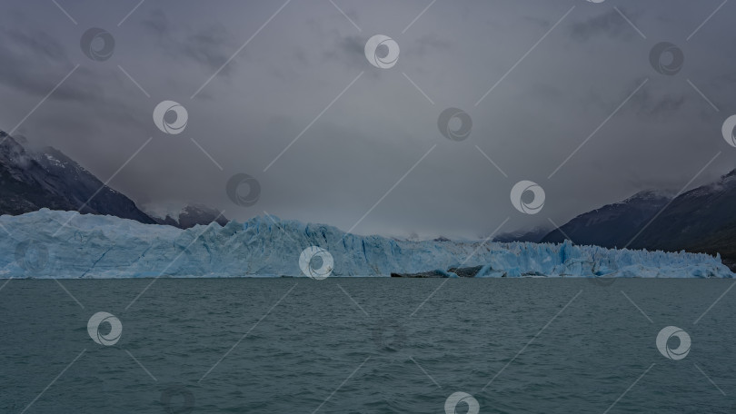 Скачать Стена из потрескавшегося голубого льда тянется поперек бирюзового ледникового озера. фотосток Ozero