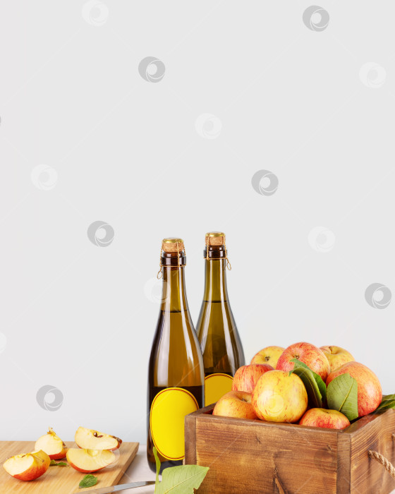 Скачать Бутылки с сидром и красными органическими яблоками на синем фоне фотосток Ozero