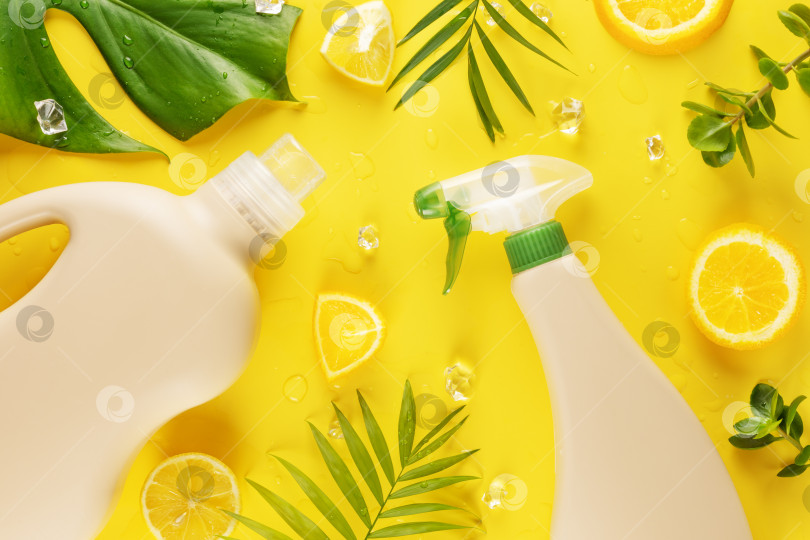 Скачать Бутылочки с натуральным моющим средством с зелеными листьями и ломтиками лимона фотосток Ozero