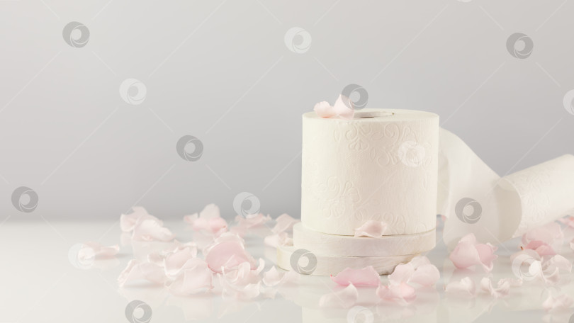 Скачать Рулон туалетной бумаги на светлом фоне с лепестками роз и пространством для копирования фотосток Ozero