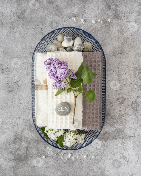 Скачать массажные камни с надписью Zen, полотенца и цветы сирени в корзине фотосток Ozero