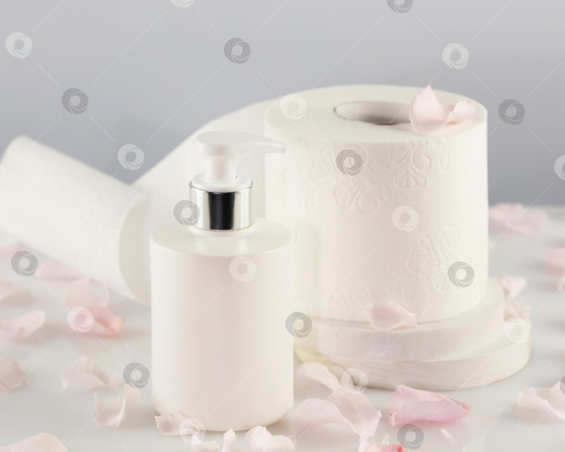 Скачать Рулон туалетной бумаги с белым флаконом-дозатором косметики и лепестками роз фотосток Ozero