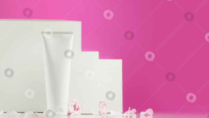 Скачать Белый косметический тюбик с белыми коробочками на розовом фоне фотосток Ozero