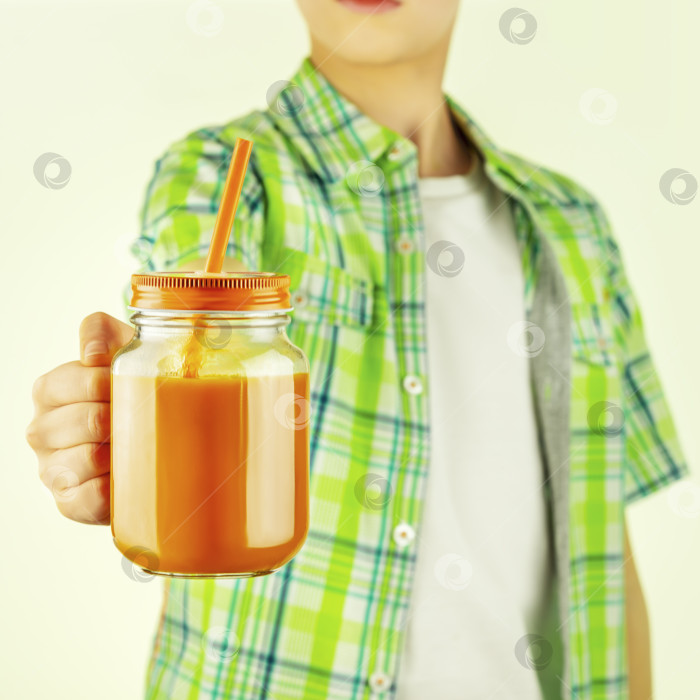 Скачать Подросток держит морковный сок в стеклянной кружке фотосток Ozero