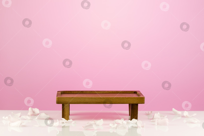 Скачать Маленький деревянный декоративный столик на розовом градиентном фоне фотосток Ozero