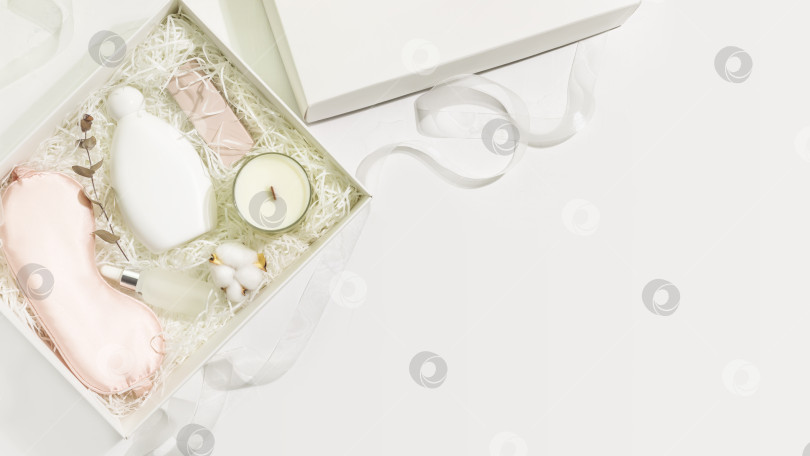Скачать Подарочная коробка с маской для сна, ароматической свечой и пеной для ванны на белом фоне фотосток Ozero