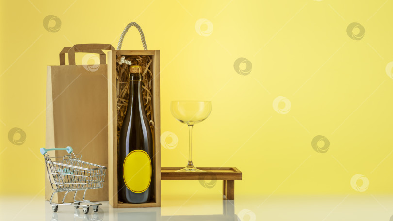 Скачать Бутылка шампанского в деревянной коробке с бокалом для вина, бумажный пакет, корзина для покупок фотосток Ozero