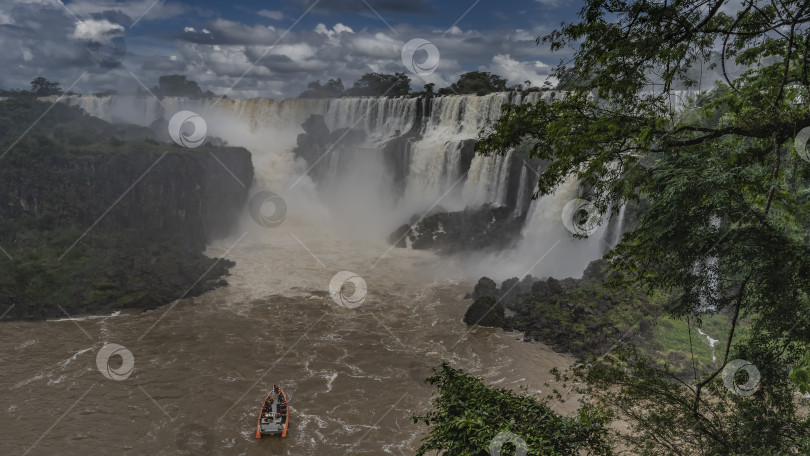 Скачать Туристический катер мчится по бурной реке к водопаду. фотосток Ozero