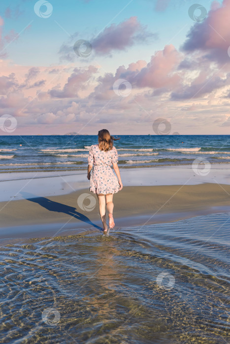 Скачать Красивая белоруска прогуливается по пляжу на фоне драматичного и романтичного неба фотосток Ozero