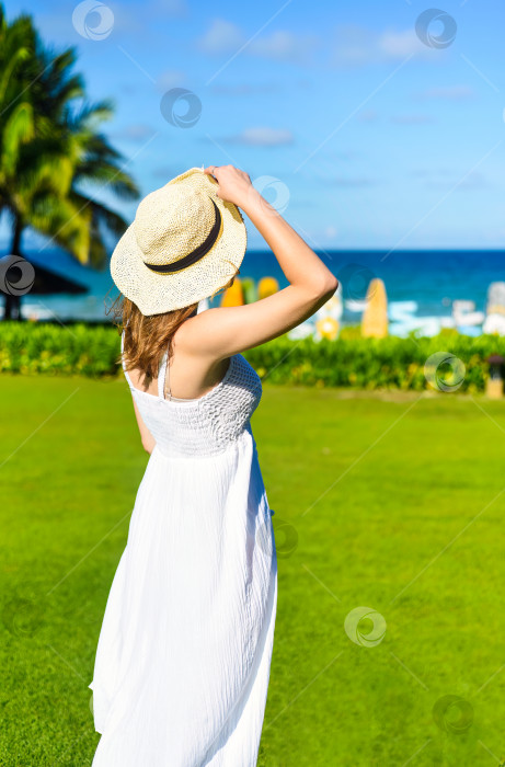 Скачать Молодая женщина из Беларуси в белом платье и шляпе на улице в солнечный день. фотосток Ozero