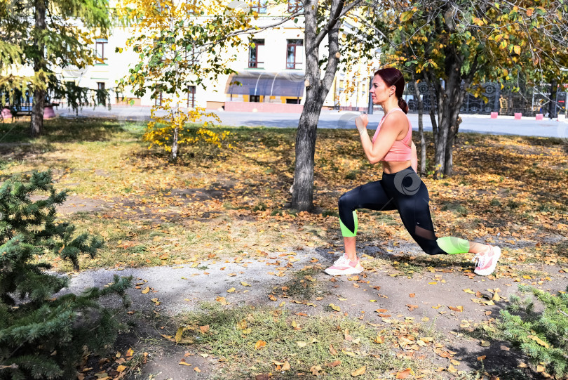 Скачать Спортсмен в удобной спортивной одежде. Фитнес на открытом воздухе в городе. Здоровый образ жизни. Тренер занимается на улице. Уверенная в себе женщина делает тренировку. фотосток Ozero