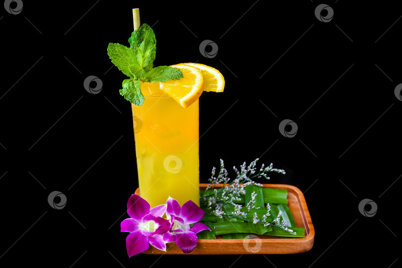 Скачать Апельсиновый сок с ломтиком апельсина, с цветами, выделенными на черном фоне фотосток Ozero