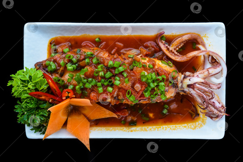 Скачать Жареные кальмары в красном соусе на черном фоне для меню фотосток Ozero