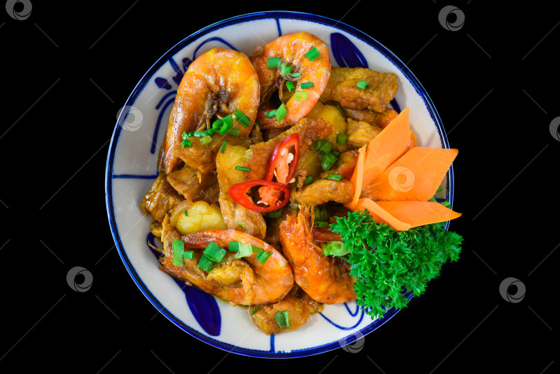 Скачать Соленые жареные креветки с соусом и овощами на черном фоне фотосток Ozero