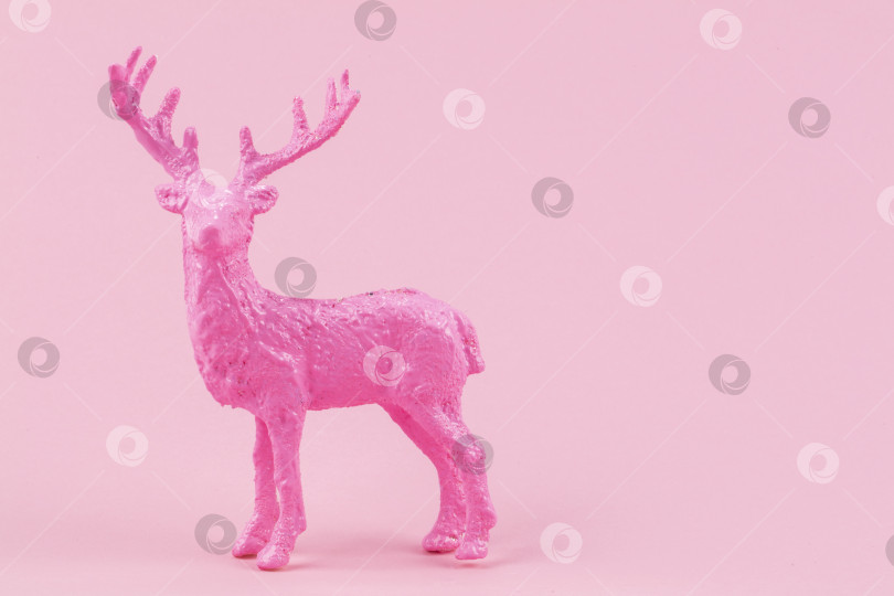 Скачать Праздничный минималистичный рождественский фон. На розовом фоне изображен розовый олень. фотосток Ozero