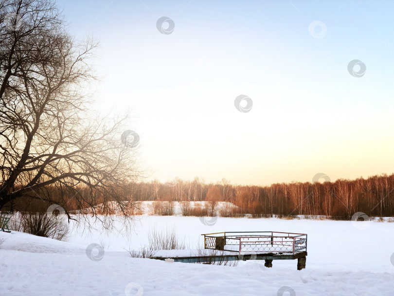 Скачать Старый пирс на берегу озера, покрытого снегом, пейзаж зимнего солнечного дня фотосток Ozero