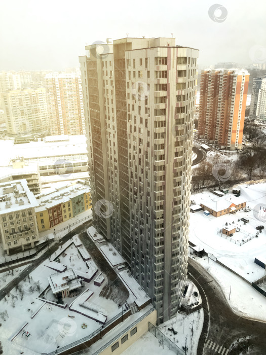 Скачать Вид с высоты птичьего полета на высотное здание в жилом районе, зимний городской пейзаж фотосток Ozero