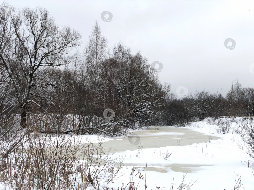 Скачать замерзающее русло реки, покрытое льдом и снегом, зимний пейзаж фотосток Ozero