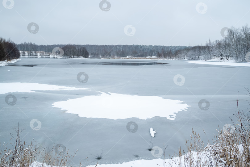 Скачать Зимний пейзаж с прорубью в центре замерзшего озера фотосток Ozero