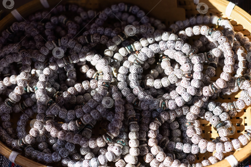 Скачать На вьетнамском рынке представлено множество браслетов-четок из дерева бодхи с белыми бусинами фотосток Ozero