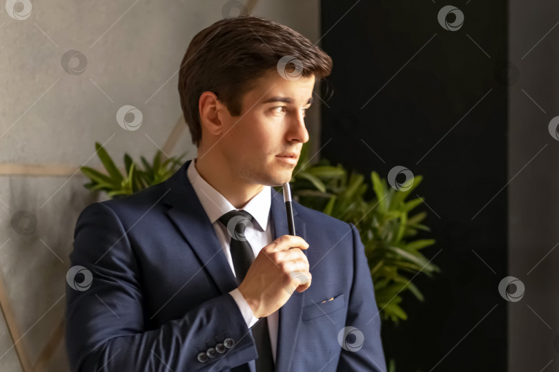 Скачать Портрет молодого красивого уверенного в себе бизнесмена с блокнотом в руках, бизнес-концепция фотосток Ozero