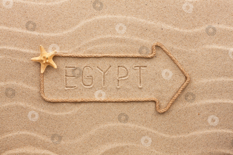 Скачать Стрела из веревки и морских раковин с надписью Egypt на песке фотосток Ozero