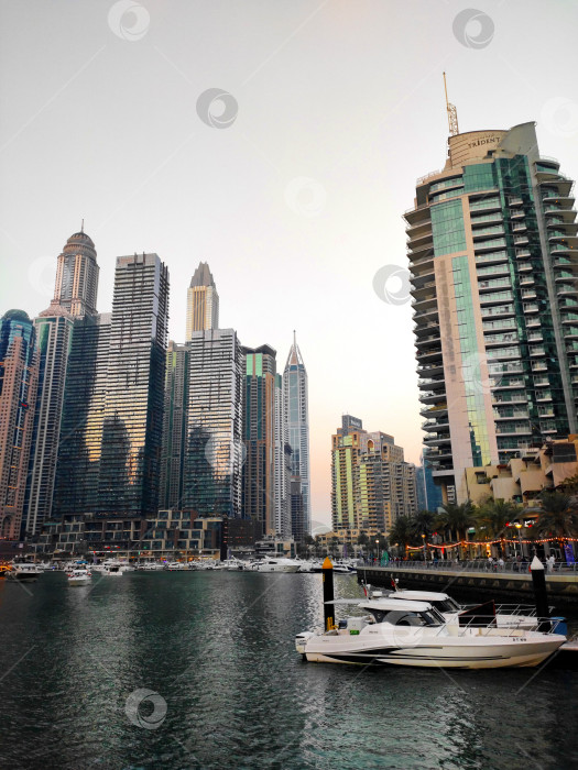Скачать Дубай, ОАЭ - 22 января 2024 года: Небоскребы в районе Дубай Марина видны с набережной на прекрасном закате. фотосток Ozero