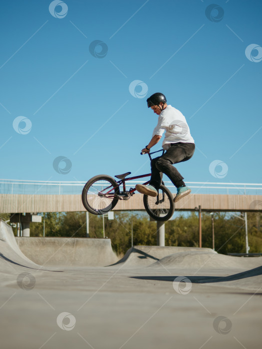 Скачать Велосипедист BMX совершает трюк с Банни-хопом и плоским хвостом-хлыстом фотосток Ozero