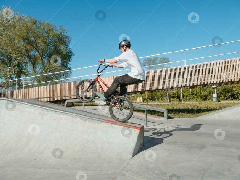 Скачать Велосипедист BMX выполняет трюк с ручным управлением на колесах фотосток Ozero