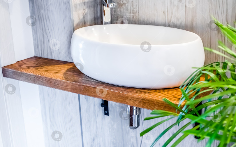 Скачать Дизайн ванной комнаты с белой раковиной и деревянной полкой крупным планом фотосток Ozero